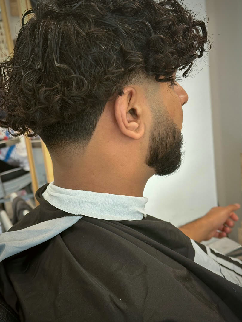 Coupe bouclée avec dégradé et barbe